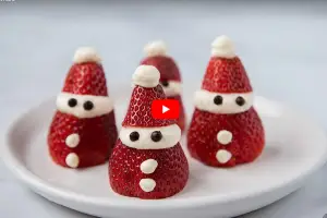 cute edible strawberries made into Santa Clauses with chocolate eyes and whipped cream faces and hats